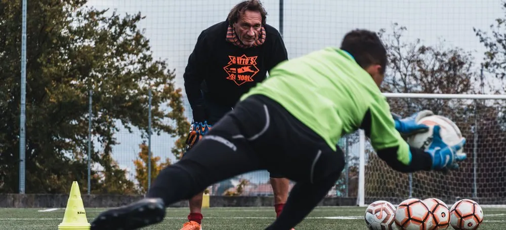 Fabio Corti segue un portiere che para a terra durante un allenamento