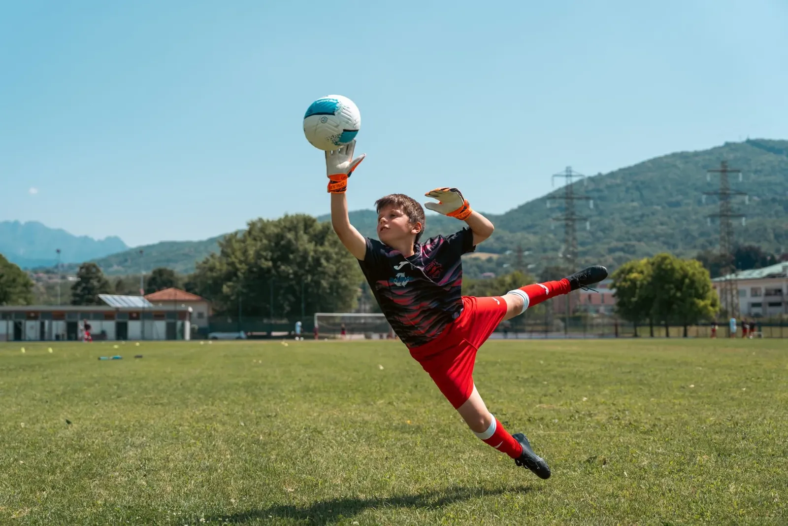 Un portiere in tuffo blocca il pallone con due mani durante il camp 2025